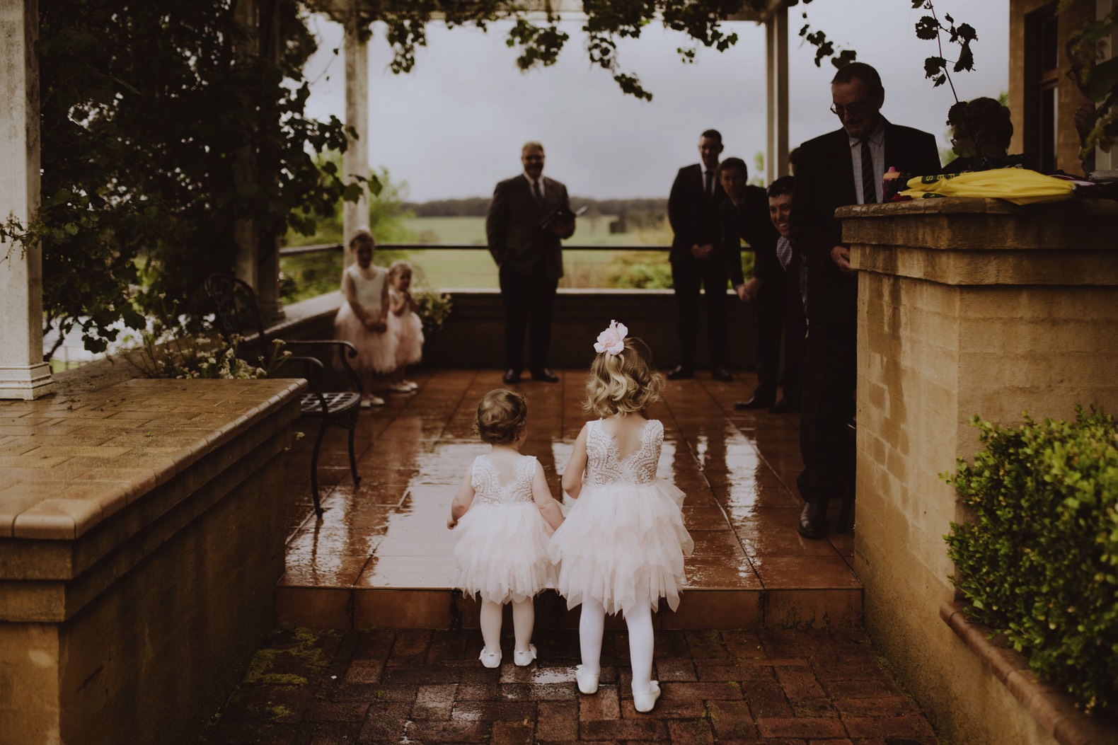 photo of flower girls walking down the aisle and rainy weather