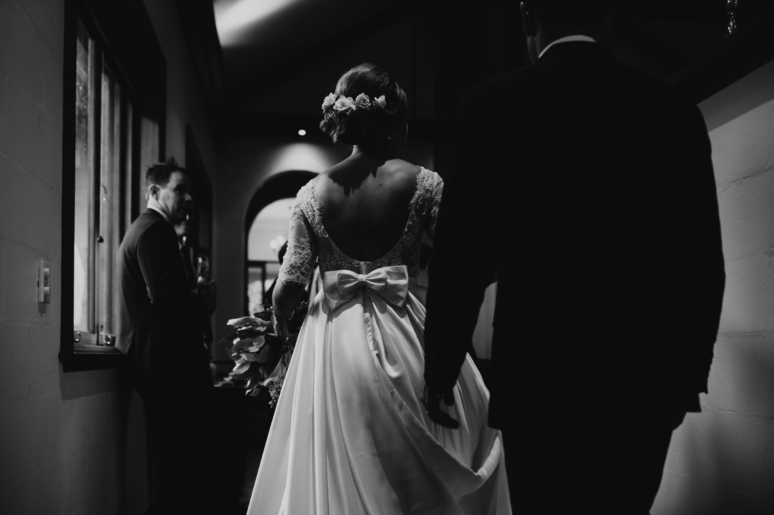 moody black and white photo of the back of brides dress