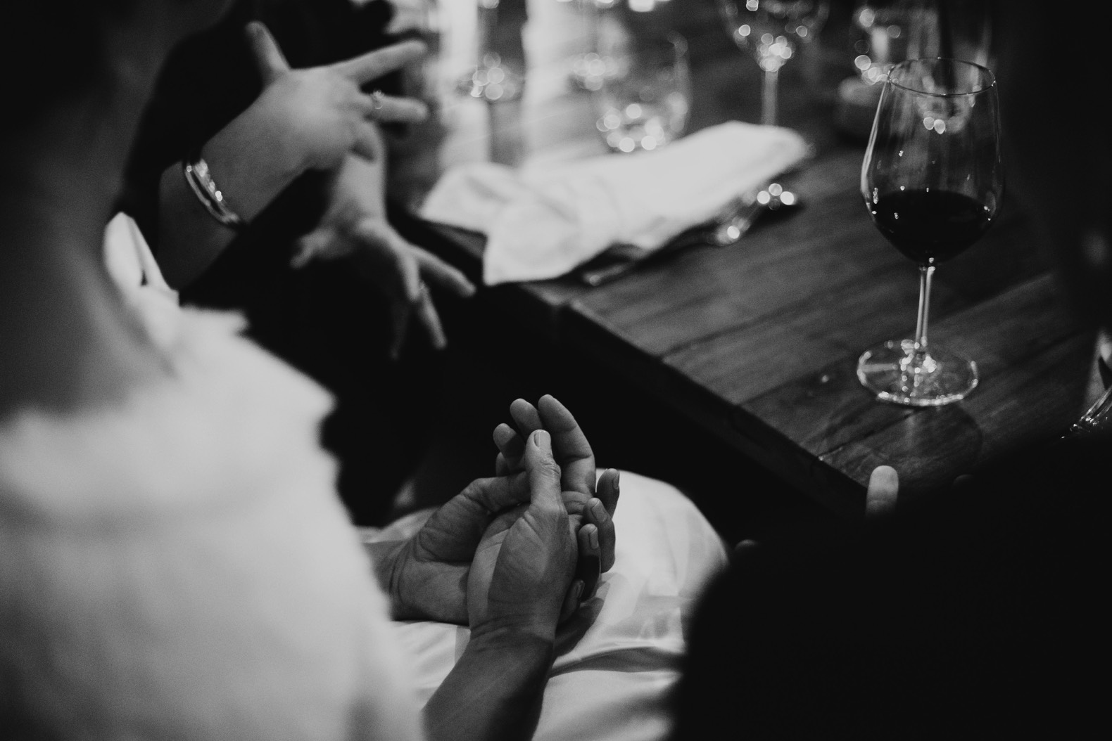 moody photo of brides hands and wine glass on table ballandean estate stanthorpe